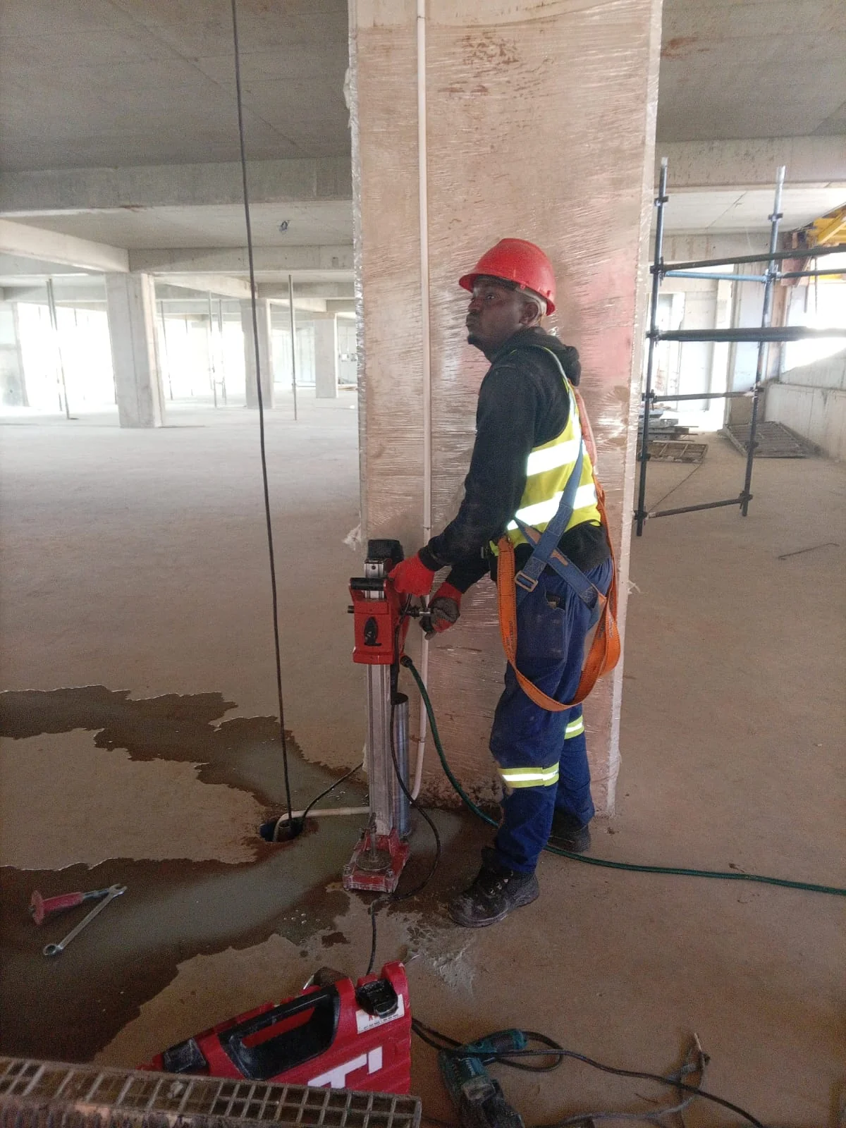 Electrician working on an open circuit board inside a wall